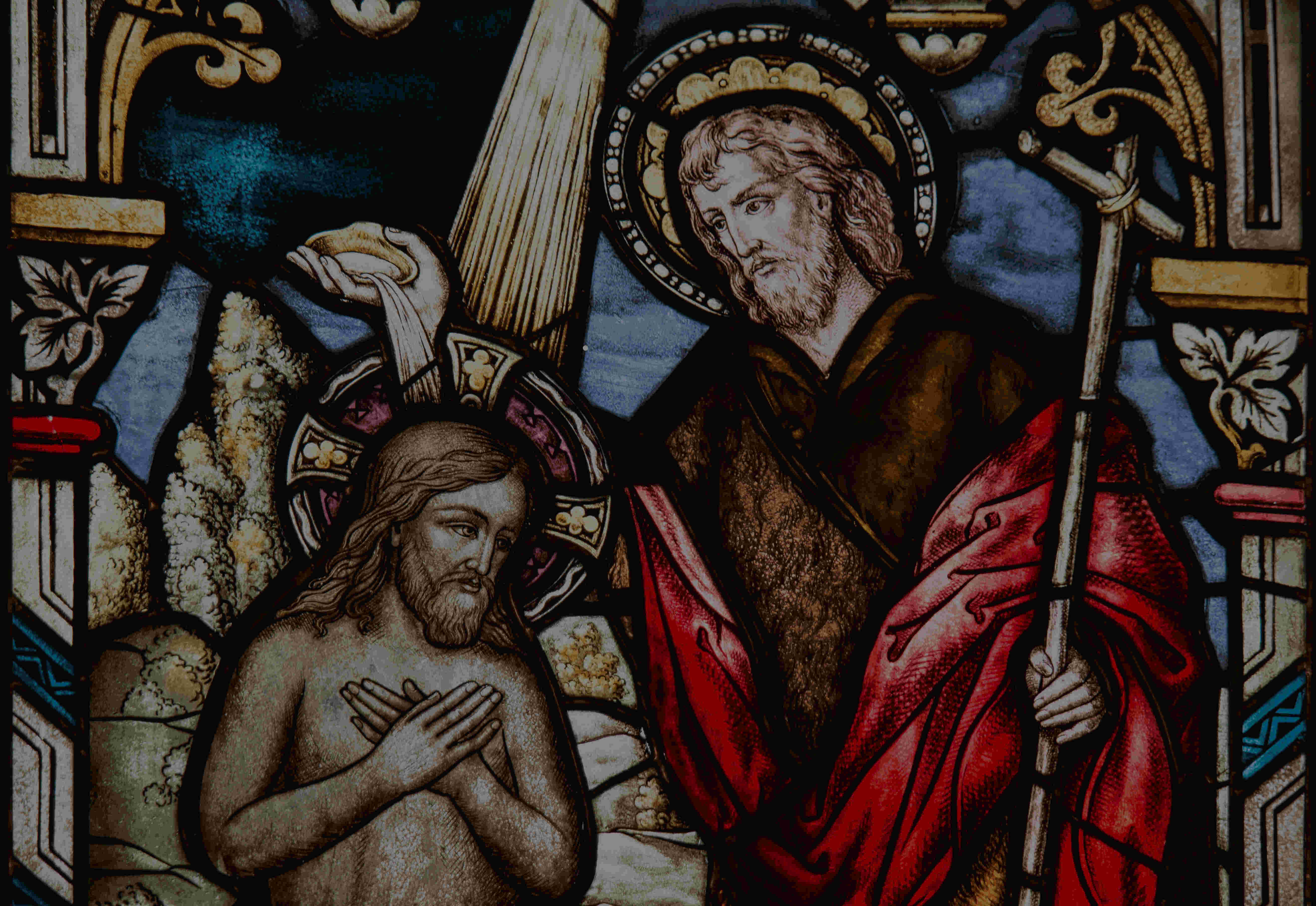 Stained glass picture of the baptism of Christ.